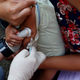 Philippine National Red Cross and Health Department volunteers conduct house-to-house measles vaccination to children in Manila, Philippines following an outbreak of measles.